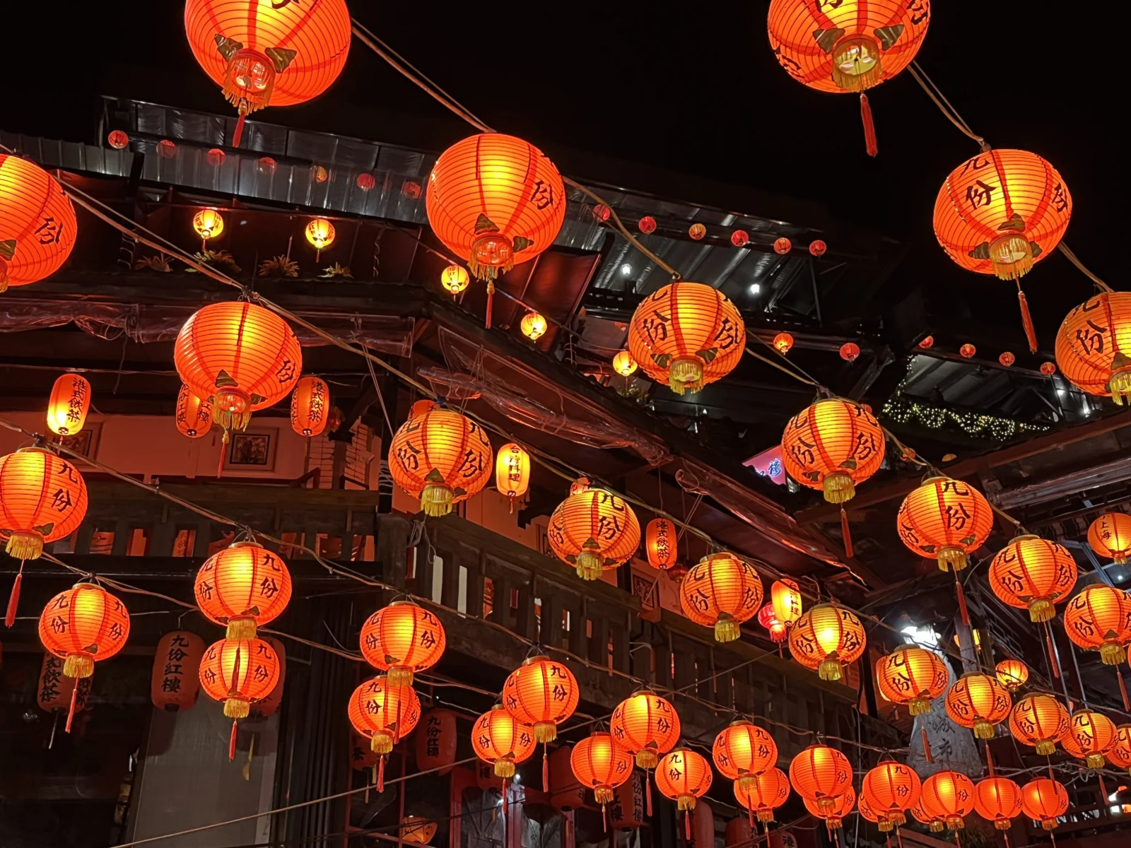 Rows of glowing red lanterns above a street in Jiufen at night