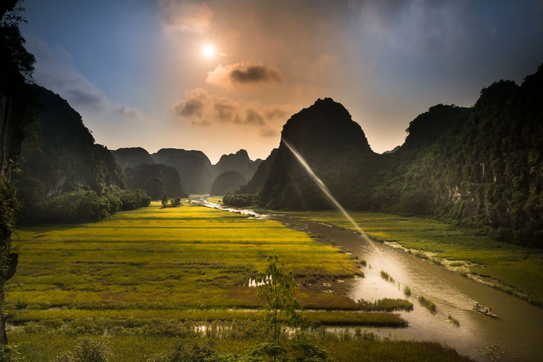 River winding through rice fields and limestone hills in Ninh Binh at sunset