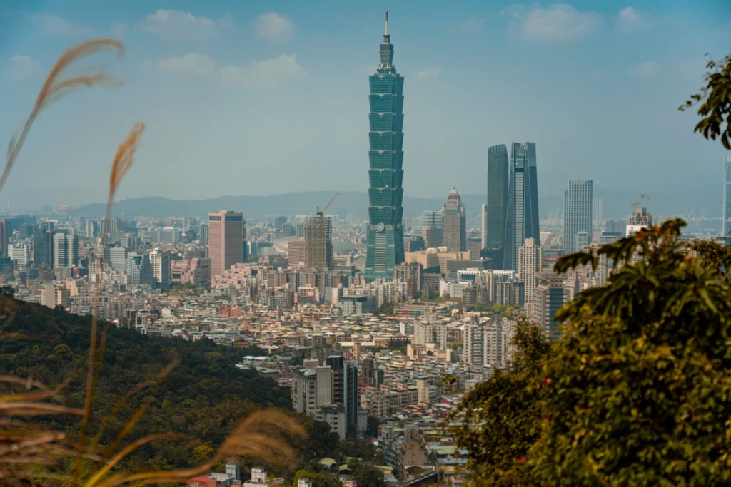 Taipei 101 rising above the city, viewed from a wooded hillside